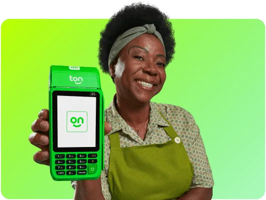 Em um fundo verde uma mulher negra está sorrindo e segurando a máquina de cartão do Ton com uma mão.
